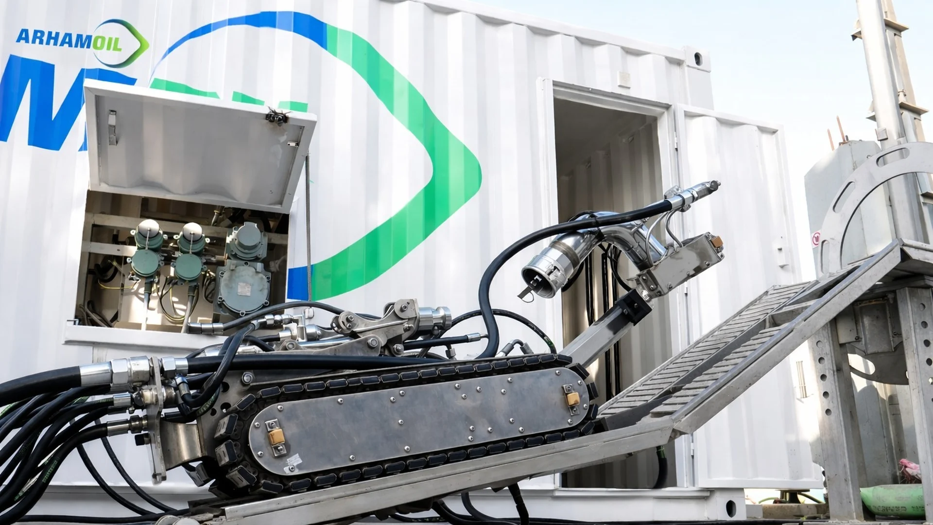 Arham Oil tracked tank-cleaning robot on its deployment ramp beside the Arham Oil field container